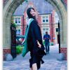 graduation image of Mia in front of arch walkway