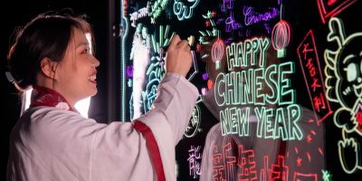 Student writes 'Happy Chinese New Year' on whiteboard