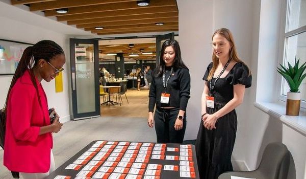 Siran and Maren greeting a conference attendee at the registration desk
