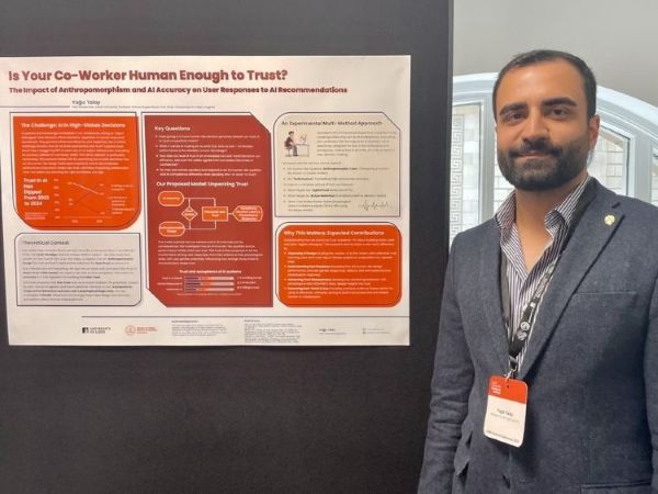 Yagiz stood in front of his research poster