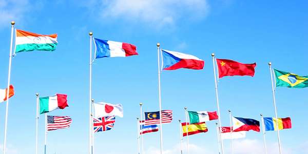 Lots of flags of different colours against a bright blue sky
