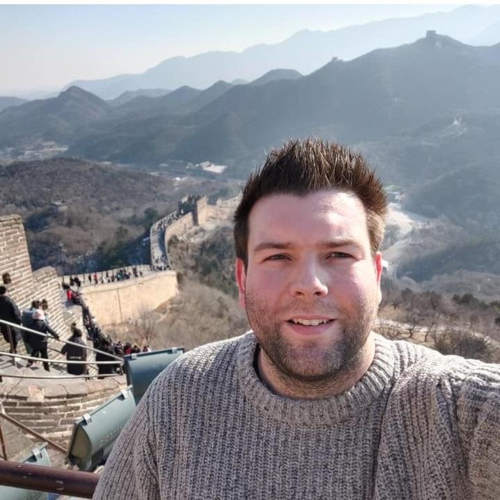 Richard Hodgett standing in front of the Great Wall of China