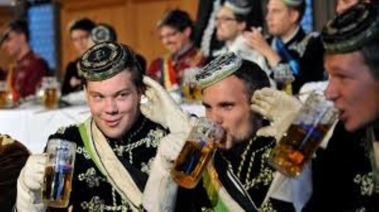 Picture shows Burschenschaften: three men in traditional attire/costume drinking beer