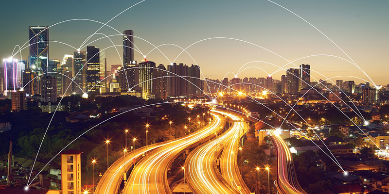 City skyline at night with lit up road and abstract arches showing connectivity