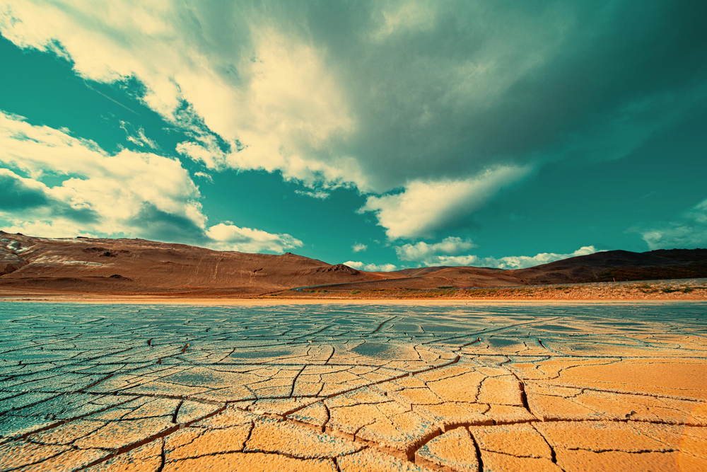 Sky full of clouds and dry, cracked land, where a lake used to be