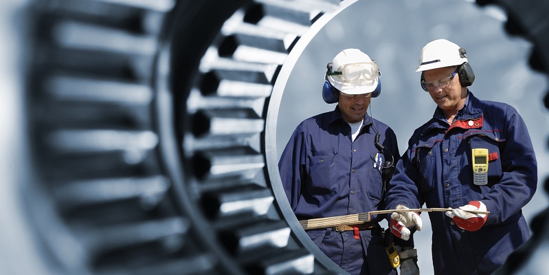 Two workers in hardhats viewed through a tunnel