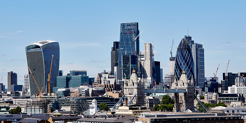 A wide shot of London city skyline against a blue sky