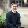 Chris Campbell sitting outside on Western Campus, Leeds University Business School