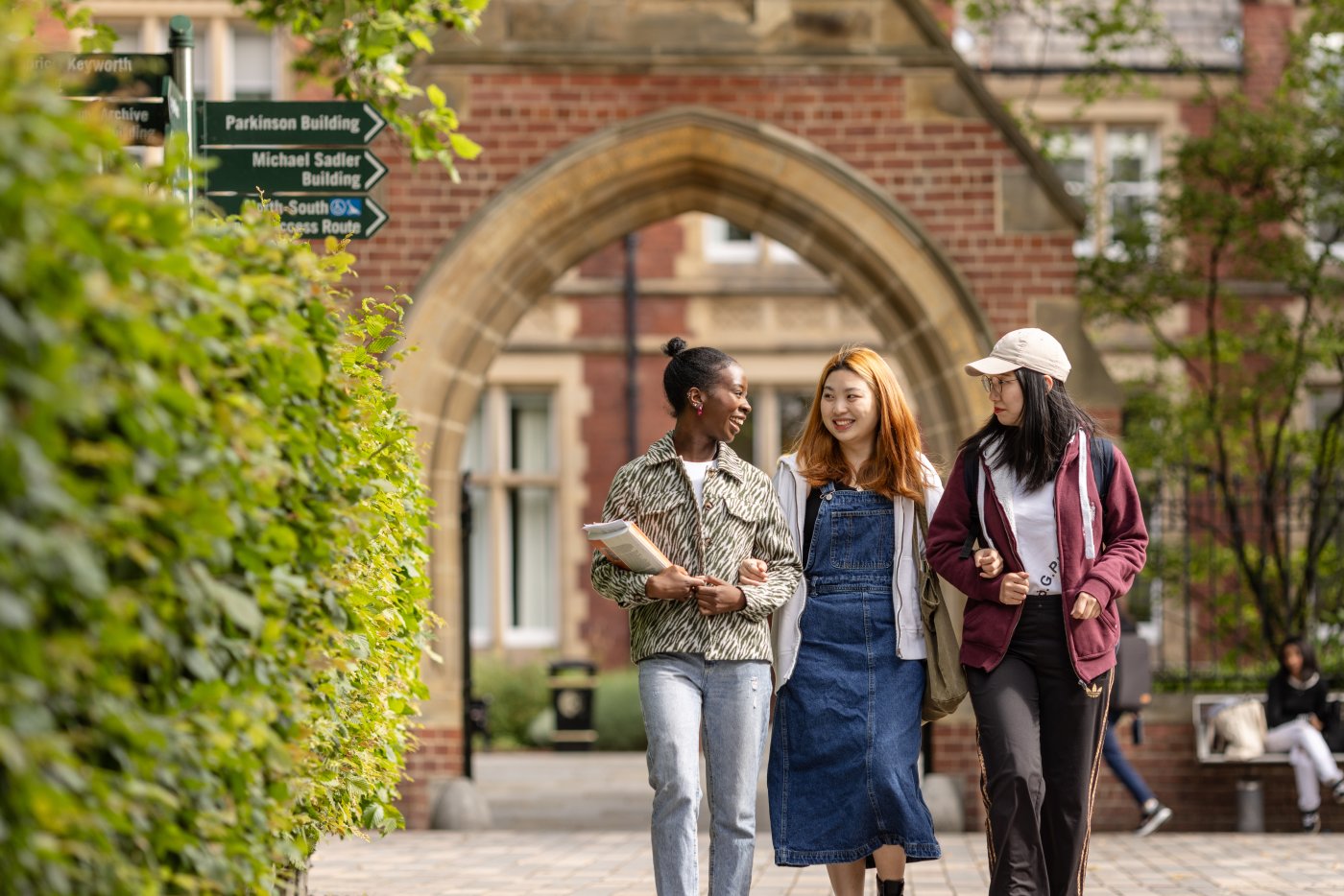 Three postgraduate students walk through the University of Leeds campus.