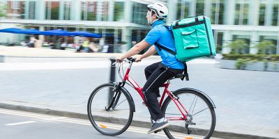 Bike courier with Deliveroo bag on back