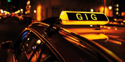 Photograph of a taxi sign atop a car, with the word 'Gig' instead of 'Taxi' being displayed