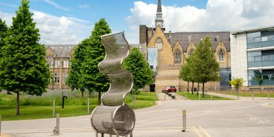 Buildings in background with metal sculpture in foreground