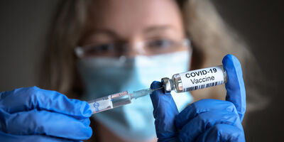 A scientist holds a syringe and a bottle with coronavirus vaccine
