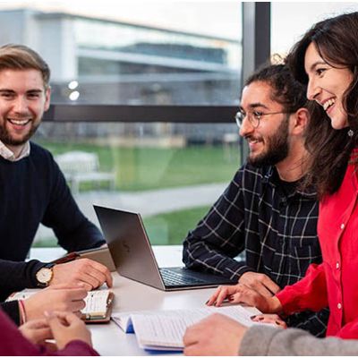 Postgraduate students around laptop.