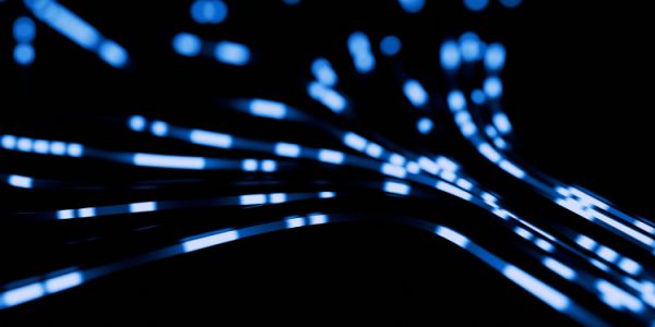 Abstract digital image of glowing blue data-like streaks curving across a black background