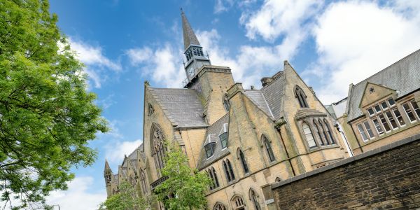 Large, historic building against a blue sky with clouds
