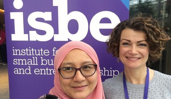 Drs Ainurul Rosli and Isla Kapasi stood in front of an ISBE banner