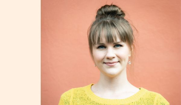 Headshot of Dr Riikka Harikkala-Laihinen against a peach-coloured background