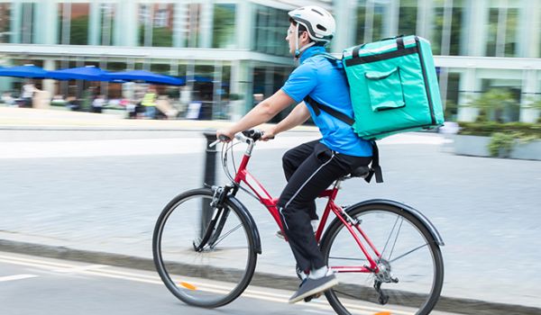 Bike courier with Deliveroo bag on back