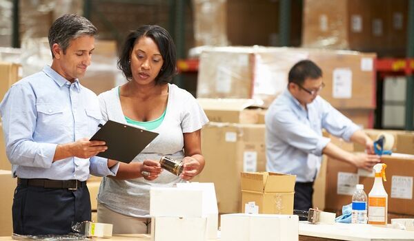 Man and woman looking at a clipboard in a factory