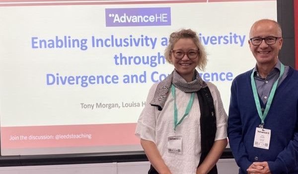 Lena Jaspersen and Tony Morgan stood in front of a presentation screen at the Advance HE conference