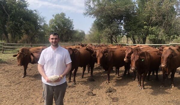 Peter Gittins stood in front of cows on a farm in South Africa