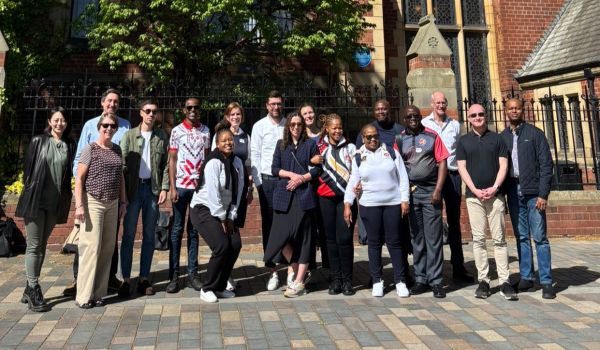 A group of workshop attendees standing outside a building on campus