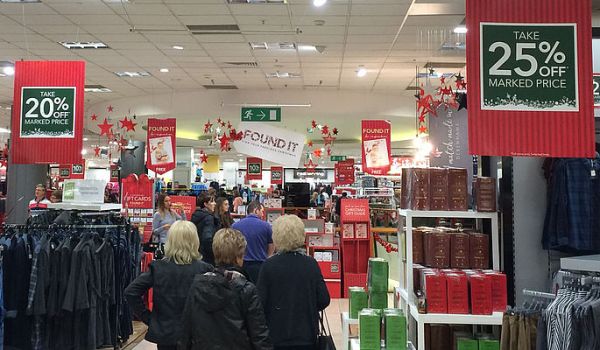 Photograph of a store interior with shoppers walking around.