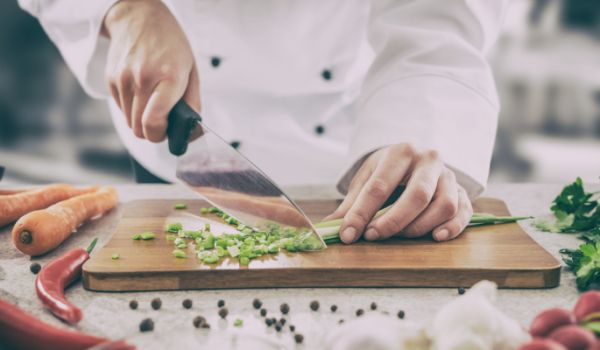Chef cutting vegetables on a chopping board