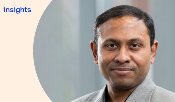 Headshot of Suman Seth with a cream curve overlay to the left, with the word 