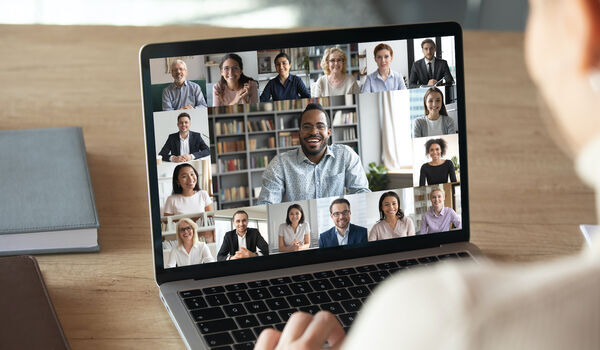 Laptop showing numerous people on a video call.