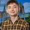 Caucasian male with short brown hair and an Orange and Brown Checked shirt