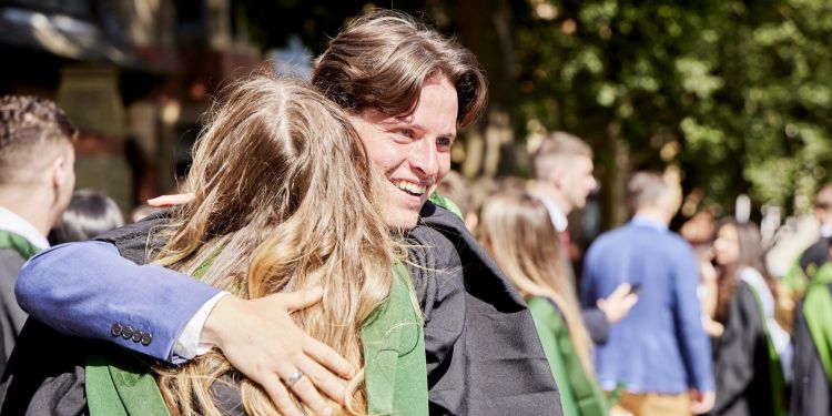 Two graduates hugging outside of the Great Hall