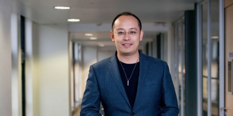 Jie Chen stood in an office corridor, smiling at the camera