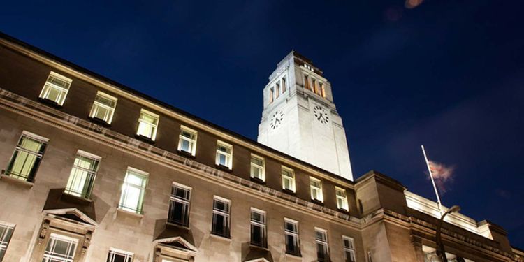 A dramatic upwards shot of the Parkinson building, lit up against a night sky