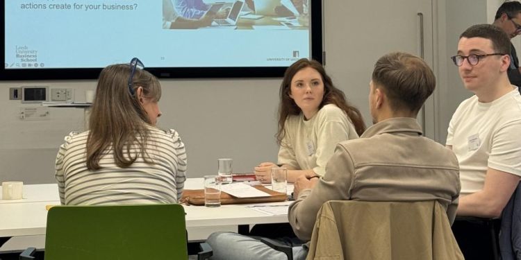 Group of event attendees sitting around a table in discussion.