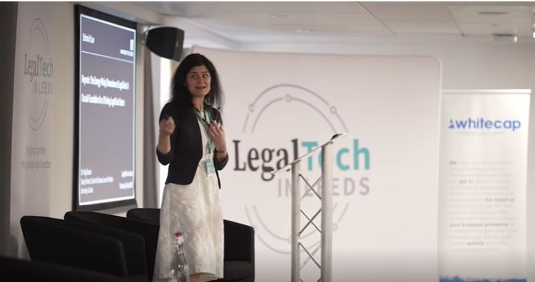 Virag Blazsek delivering her presentation in front of a "LegalTech in Leeds sign"