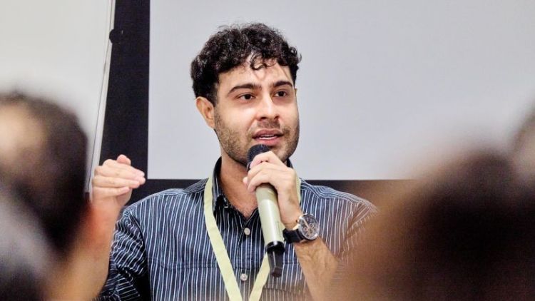 Sanjay Popat speaking into a microphone