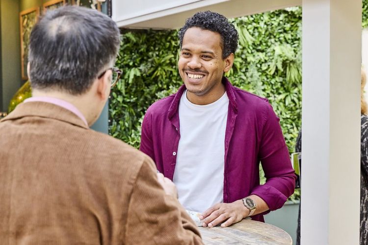 Two men having a conversation smiling