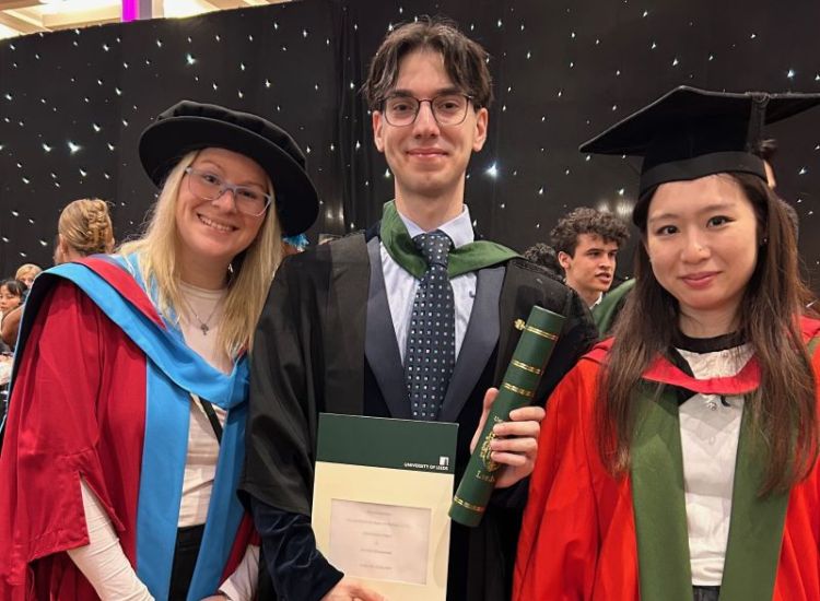 Nathalie Benesova, Hamzeh Qaraman and Winnie Lam in graduation gowns, with Hamzeh holding his graduation certificate.