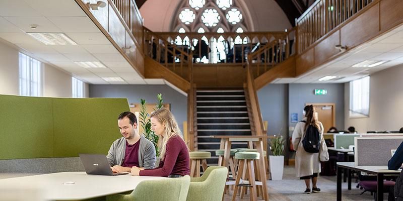 The postgraduate private study room with wooden beams and stained glass windows