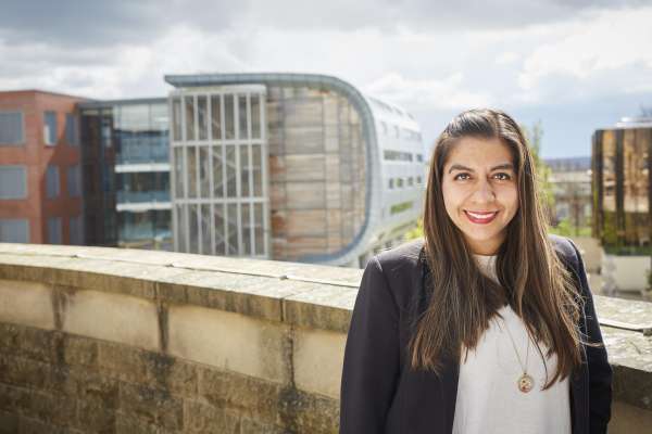 MBA student with campus buildings in background