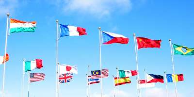 Lots of flags of different colours against a bright blue sky