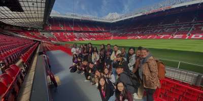 Nathalie and her students stand in Old Trafford Stadium