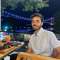 Image of alumnus Reda Al Zahrawi in front of a lit up bridge at night