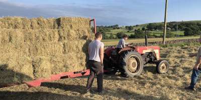 Farmer on tractor loaded with hay