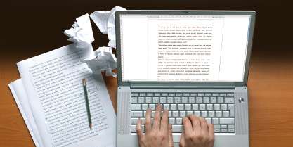 Image of a laptop upon which someone is writing