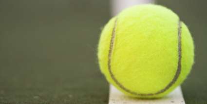 Photograph of a tennis ball on a tramline.