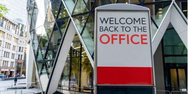 A sign outside an office building saying 'welcome back to the office'